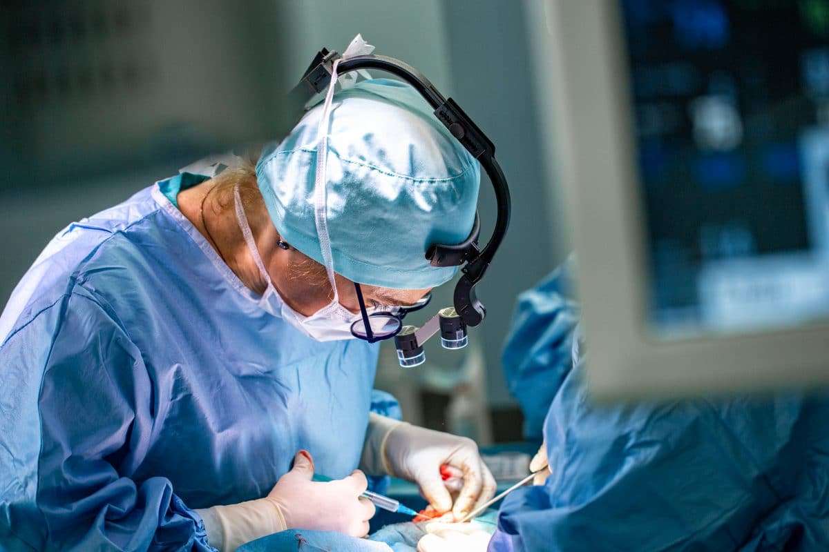 Chirurg schreibt seine Initialen auf Leber von Patienten